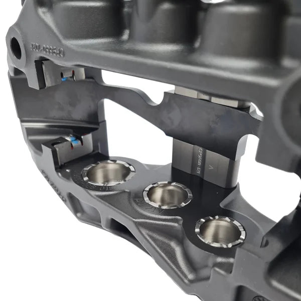 Close-up of AP Racing Pro 5000R brake caliper showing forged aluminium body and precision machining